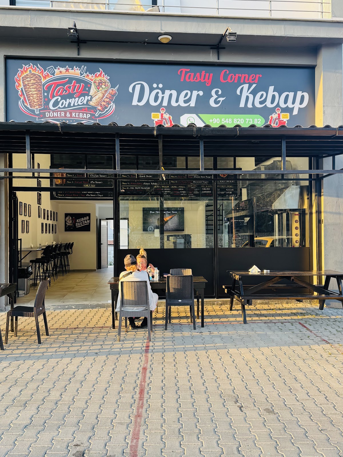 Tasty Corner'ın Lapta'daki dükkanı, dış cephe ve oturma alanı